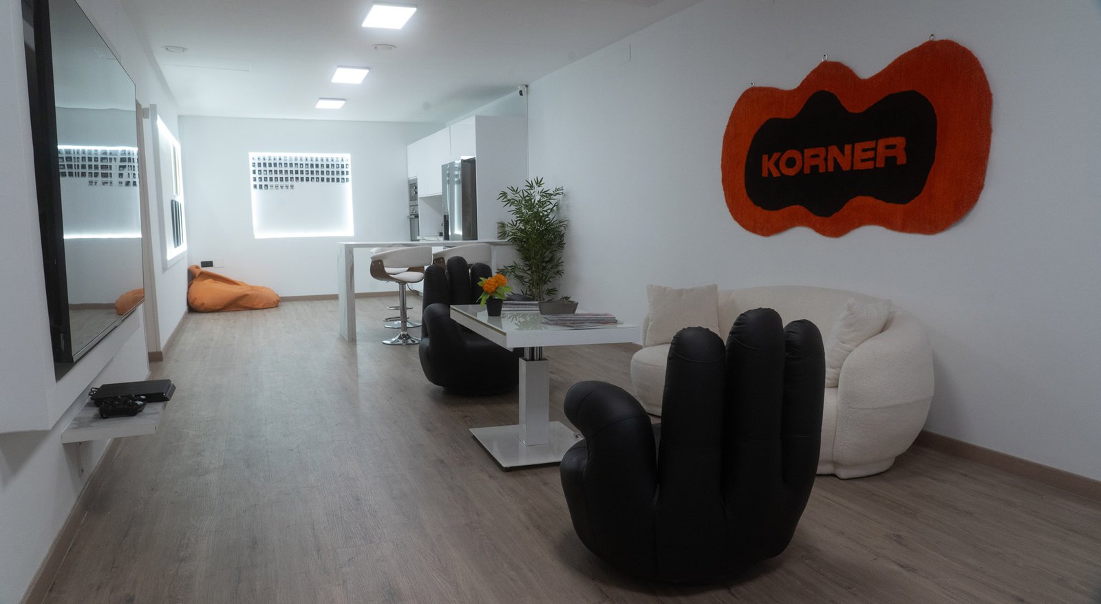 Zona de estar con sillones en forma de mano y la alfombra de Korner